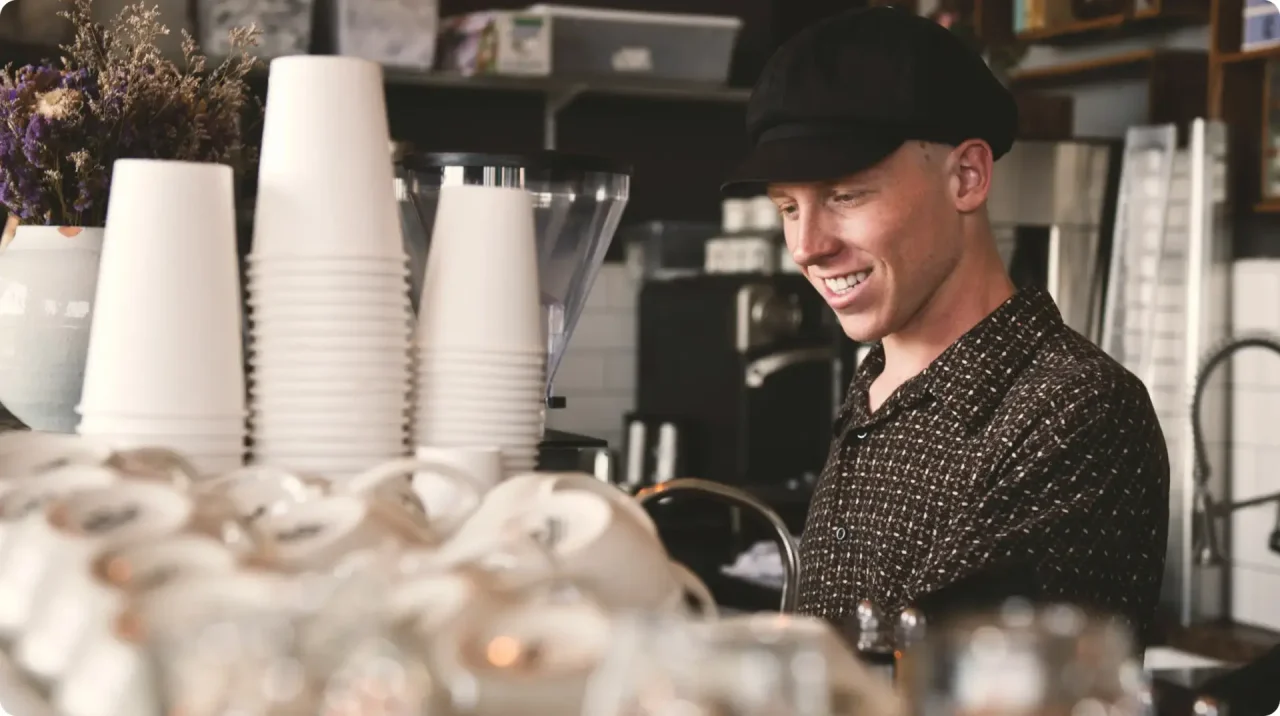 Barista Working Behind Counter In Coffee Shop