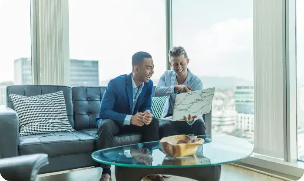 Two Businessmen Reviewing Laptop During Office Meeting