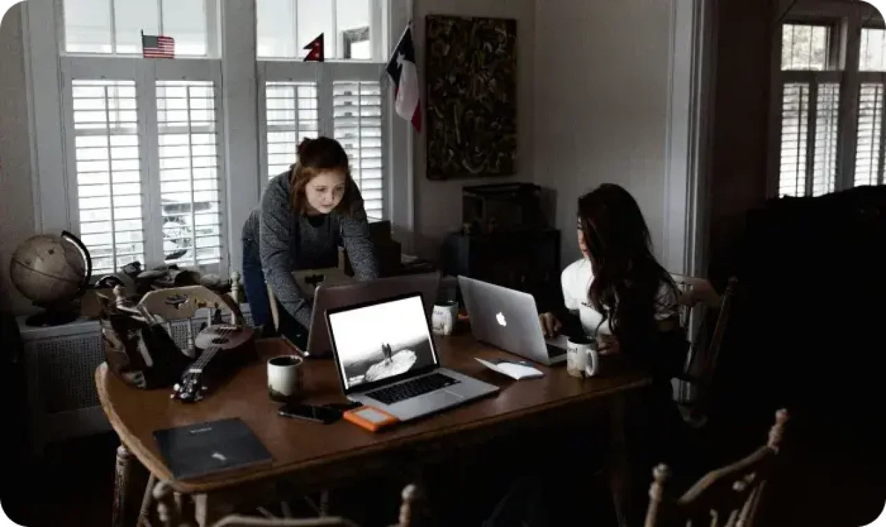 Two people working on laptops