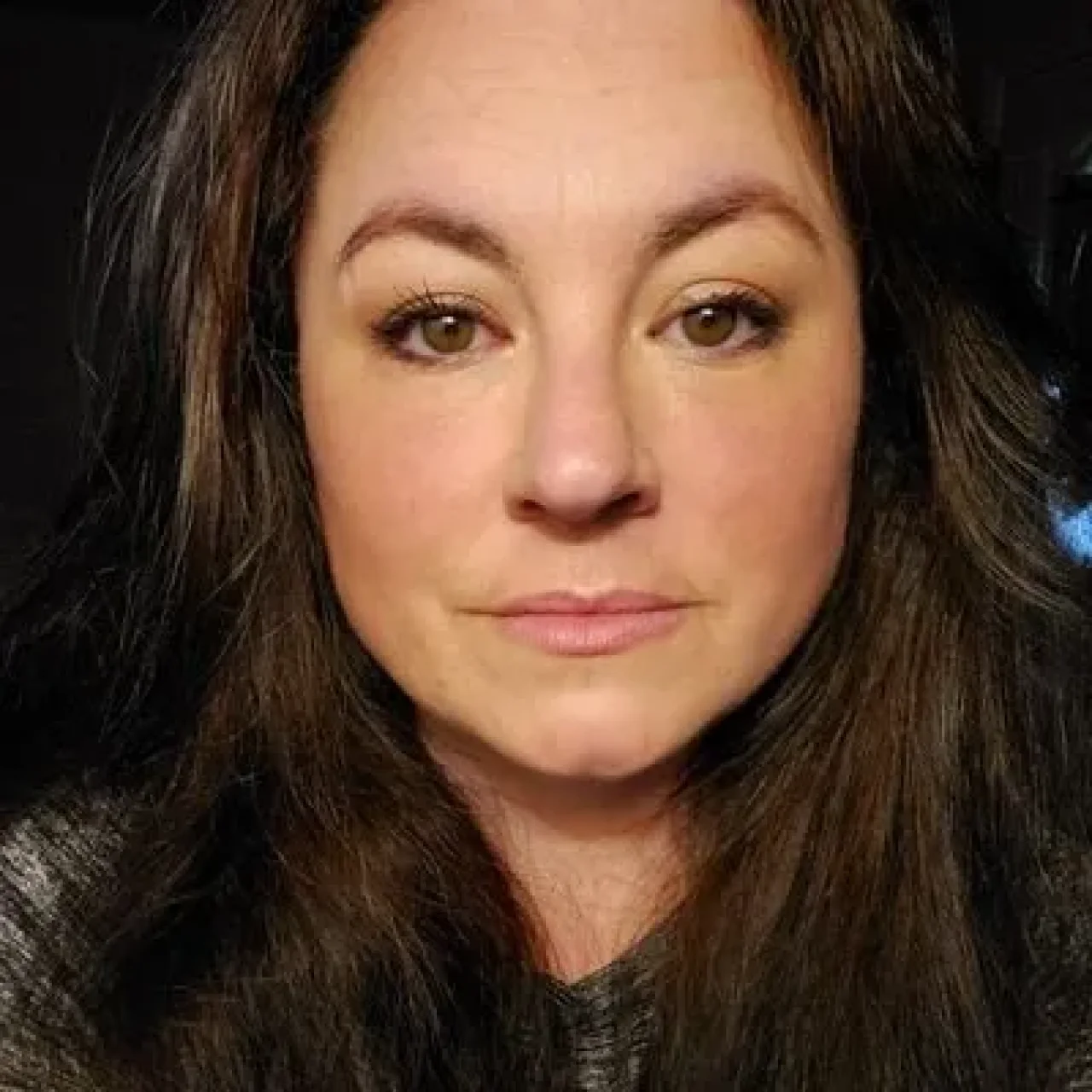 Jennifer Grant, smiling, wearing professional attire, with a neutral background